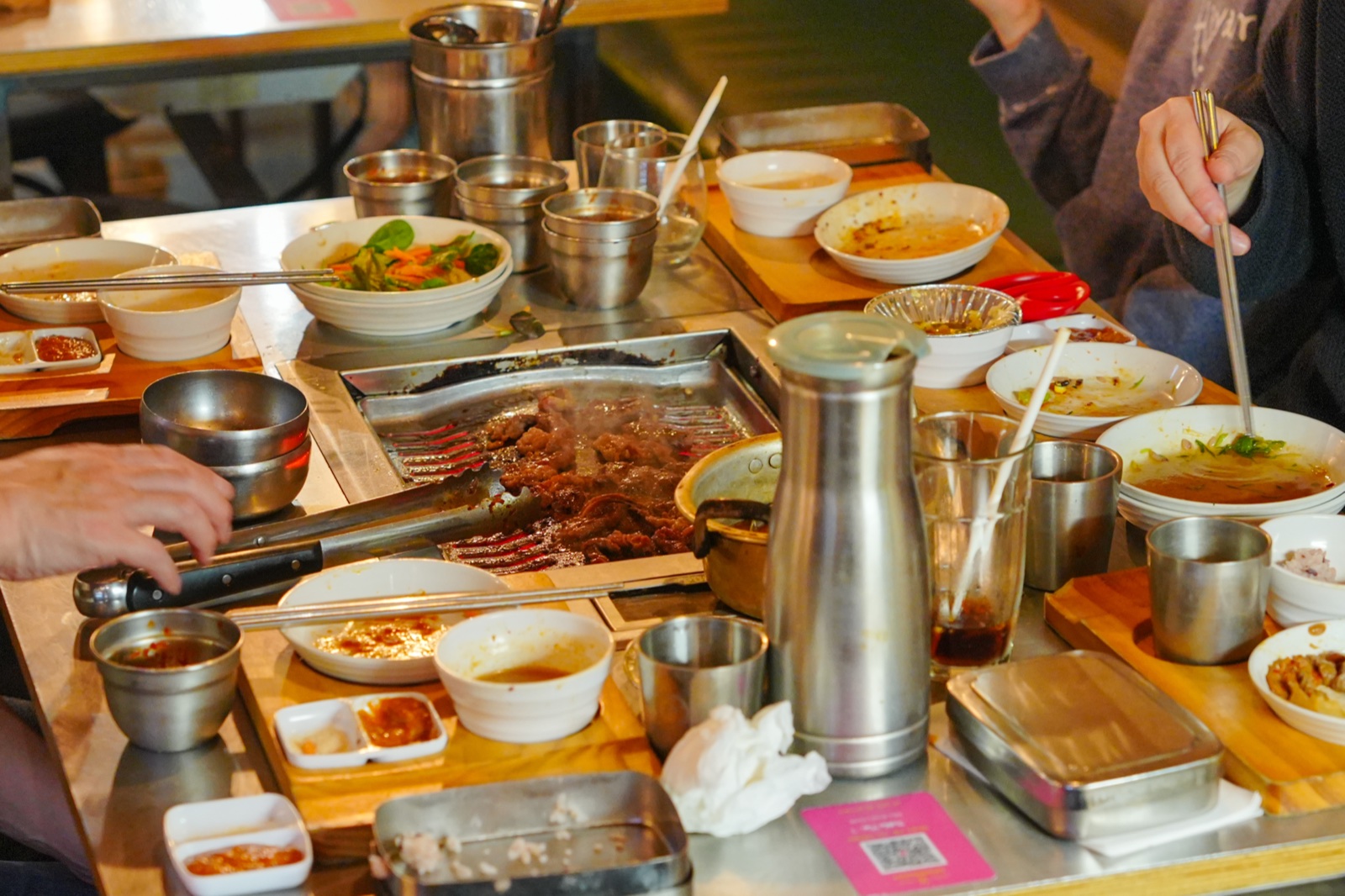 Guests cooking Korean BBQ around the table grill